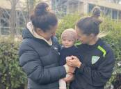Canberra United's Ellie Brush (right) with two of the things driving her decision to return to the capital. Her wife Kristy Sutcliffe, and five-month-old son Leo.