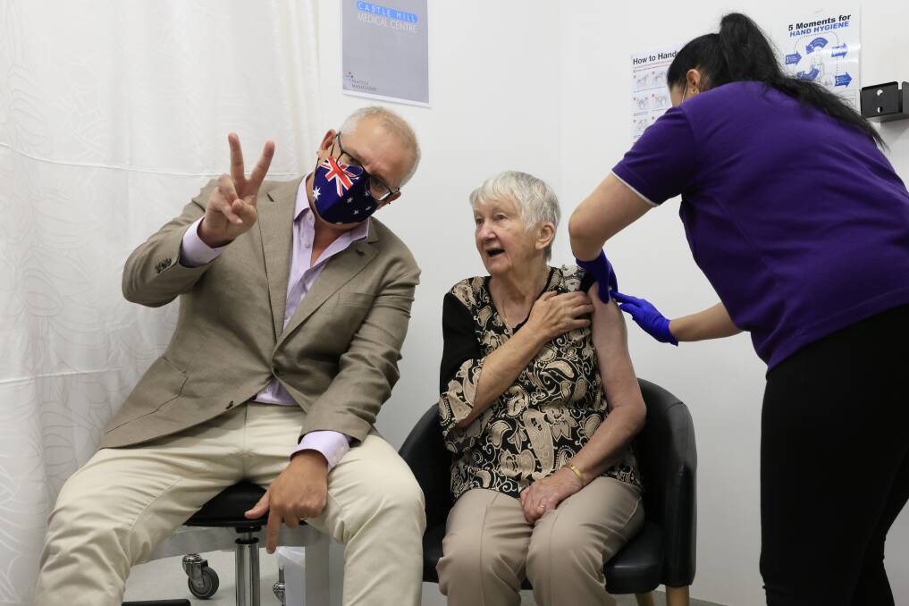 Prime Minister Scott Morrison makes the V for victory sign as Jane Malysiak, 84, gets the jab. Picture: Getty Images