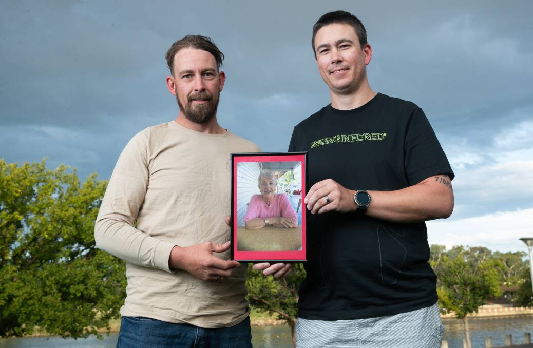 Brothers Luke Maddison (left) and Jake Maddison with a photo of their grandmother Jacqui Maddison, who died from COVID-19 in March 2020. Picture: Keegan Carroll