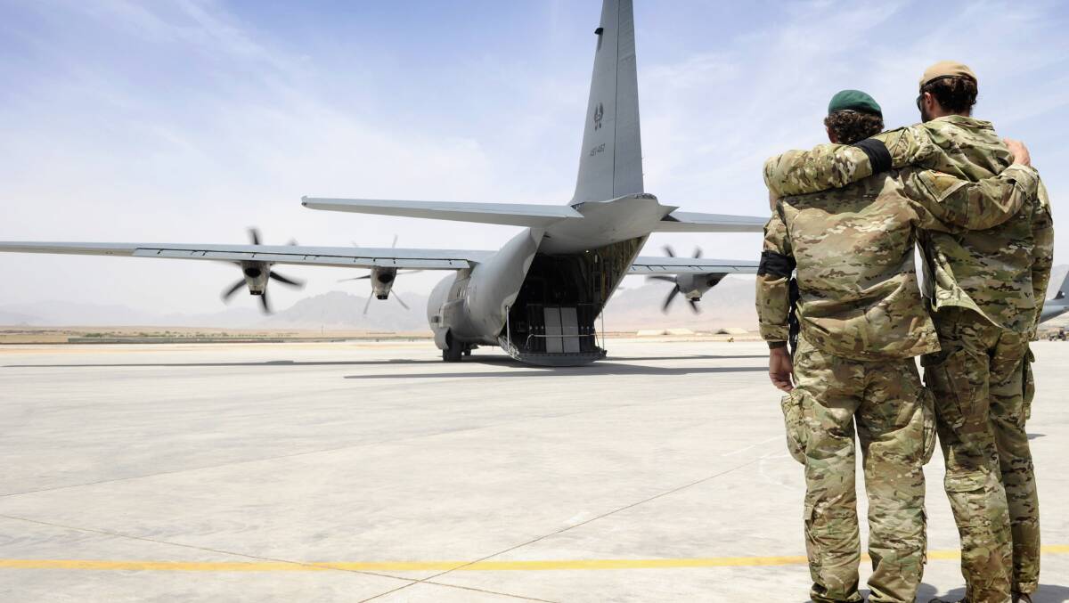 Two special forces soldiers embrace as the C-130 carrying Sergeant Brett Wood, departs Tarin Kot Airfield in 2011, in Uruzgan, Afghanistan. Picture: Getty Images