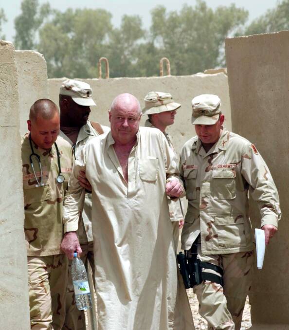 Australian hostage Douglas Wood (C) is escorted by US military after he was freed by the Iraqi Army in Ghazaliya. Picture: Getty Images/US Army