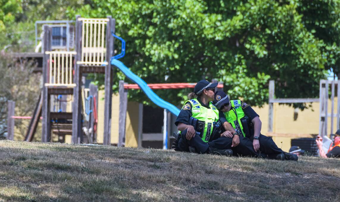 Two police officers console each other in the grounds at Hillcrest Primary. Picture: Simon Sturzaker
