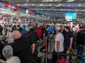 Queues of people are seen at the Virgin and Jetstar departure terminal at Sydney Domestic Airport in Sydney on Thursday. Picture: AAP