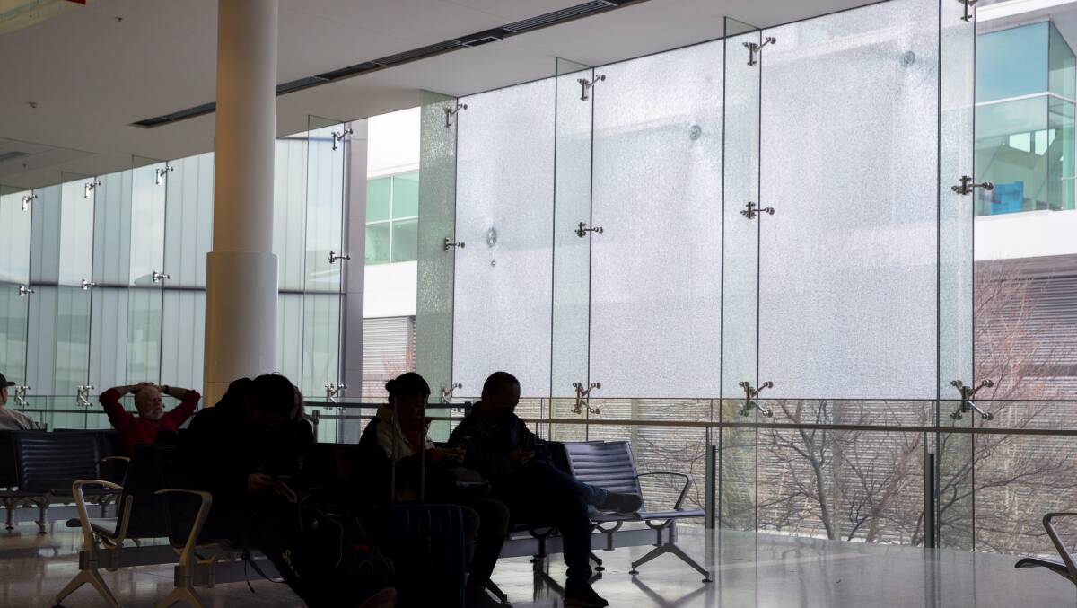 Bullet holes in glass at Canberra Airport after a gun was fired in the terminal. Picture: Keegan Carroll