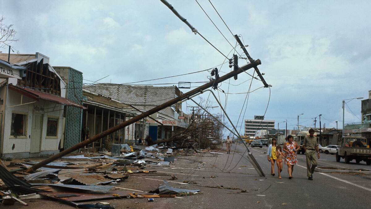 People walking through debris-laden street in Darwin after Cyclone Tracy hit on Christmas morning, 1974. Picture: Getty Images 