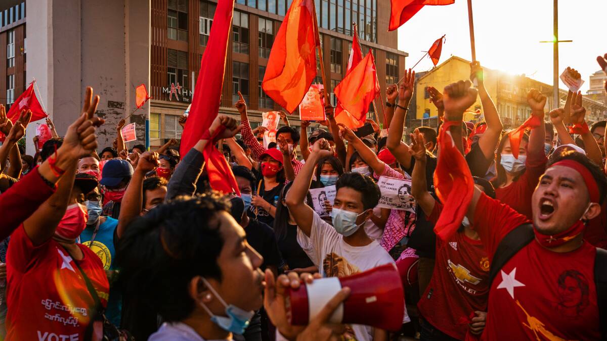 Protesters shout slogans while carrying red flags during a protest last month in downtown Yangon, Myanmar. Picture: Getty Images