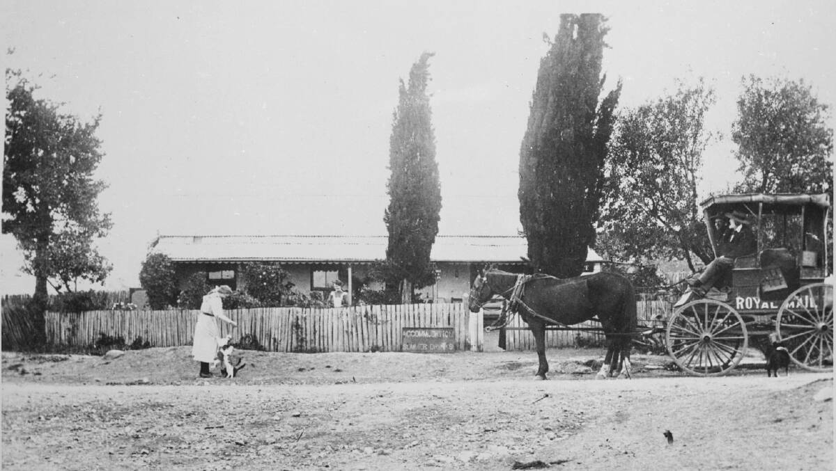 Canberras first post office circa 1909 showing postmistress Mrs Priscilla Murty and her daughter Agnes Jane playing with their pet cats. Picture: Howard and Shearsby, NLA