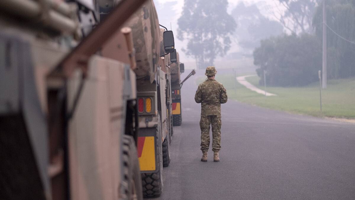 Australian Defence Force personnel prepare their trucks before starting the convoy to Mallacoota during the Black Summer bushfires. Picture: Getty Images