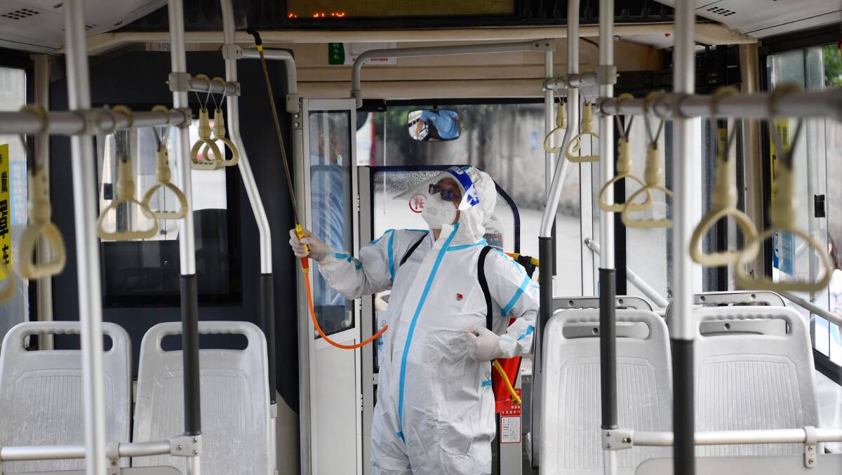 A staff member wearing personal protective equipment (PPE) disinfects a bus at a bus station on September 5, 2022 in Chengdu. Picture Shutterstock
