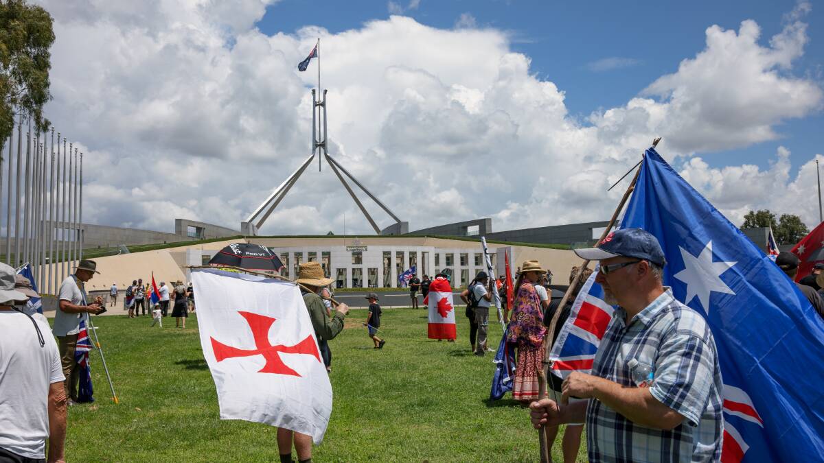 The flag of the Knights Templar (left), often wielded by far-right extremist groups, was brandished outside Parliament. Picture: Sitthixay Ditthavong