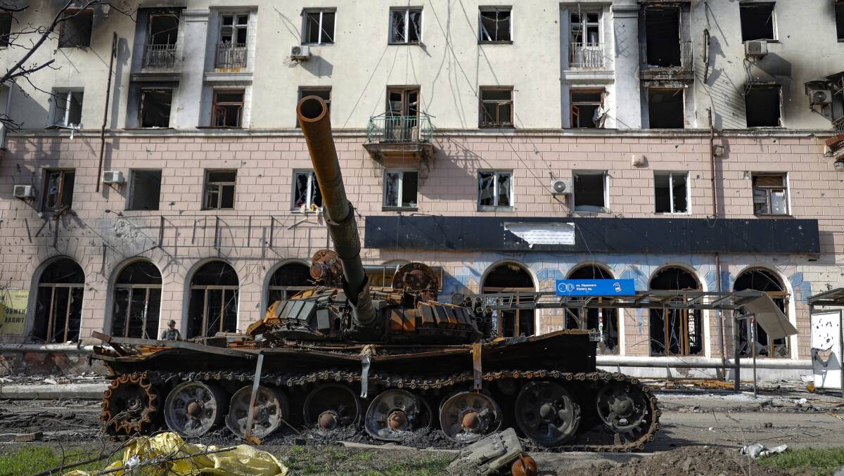 A destroyed tank and a damaged apartment building from heavy fighting are seen in an area controlled by Russian-backed separatist forces in Mariupol on Tuesday. Picture: AAP