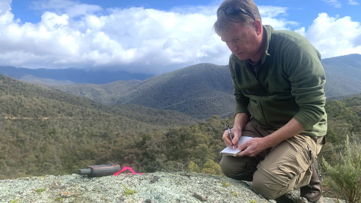 Dr Andrew Claridge documents details of four spotted-tailed quoll scats atop a rock platform in the Byadbo Wilderness. Picture by Tim the Yowie Man