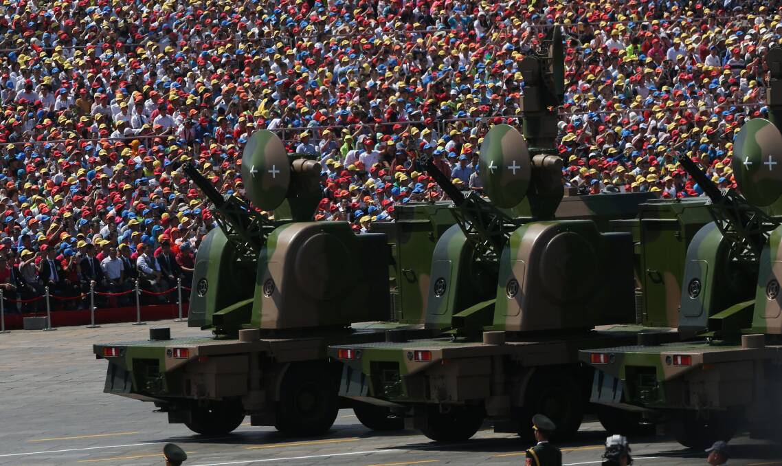 Military vehicles drive past Tiananmen Gate and thousands of people celebrating China's 70th anniversary. Picture: Getty Images