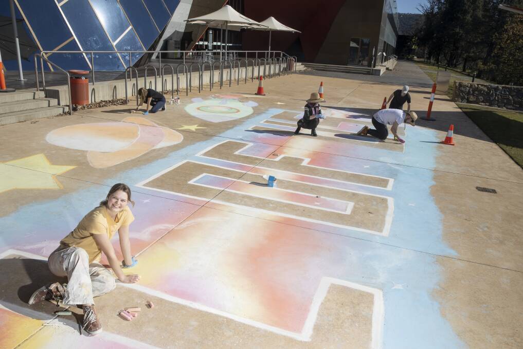 Hannah Pengilly and her troupe of helpers work on a chalk mural outside the National Museum of Australia. Picture: Sitthixay Ditthavong 