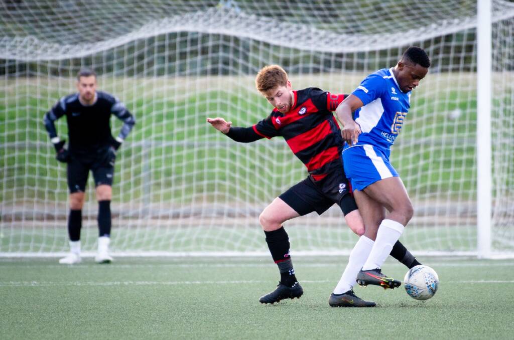 Canberra Olympic's Aisosa Ihegie (right) tussles with West Canberra's Connor Bill. Ihegie won a late penalty for his side. Picture: Elesa Kurtz