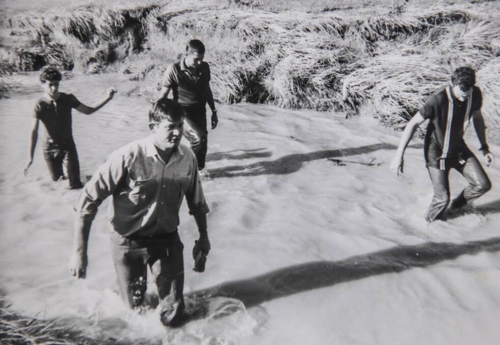 Police wade through a stormwater drain searching for bodies of victims of the flash floods after the Woden floods on January 26, 1971.
