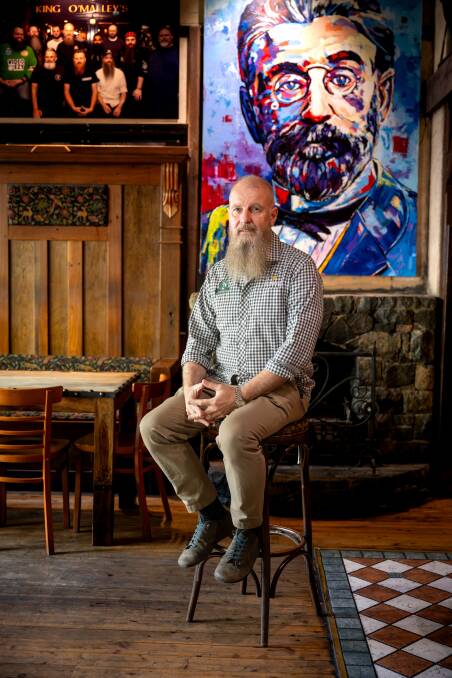 King O'Malley's owner Peter Barclay, with one of the many portraits of the pub's namesake. Picture by Sitthixay Ditthavong