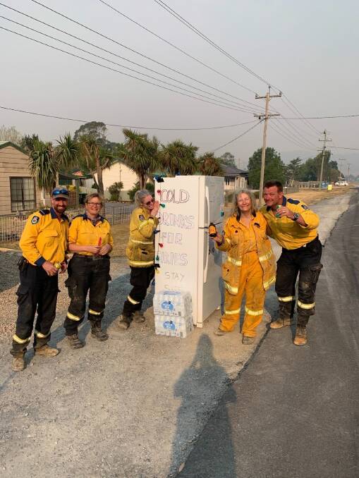 Firies enjoying a cold drink, thanks to the fridge set out by the Hooper family of Bungendore in January 2020. The fridge has been acquired by the National Museum of Australia. Picture: Carwoola Rural Fire Brigade