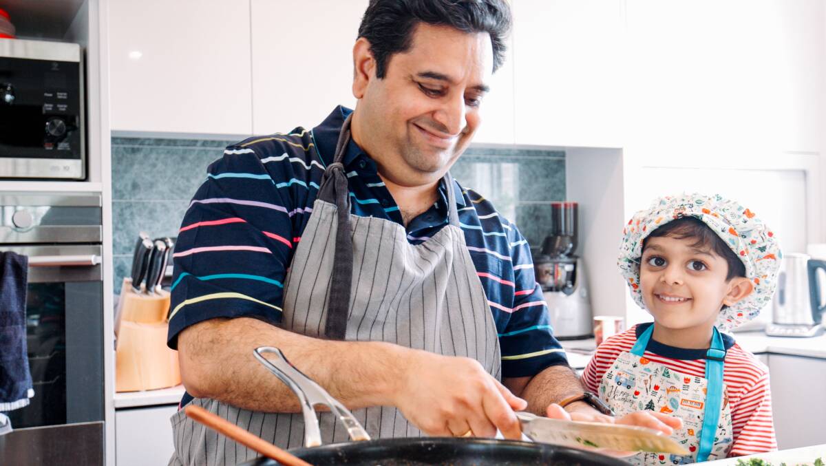 Sam Gupta shows his son Som some culinary tricks. Picture Creswick Collective