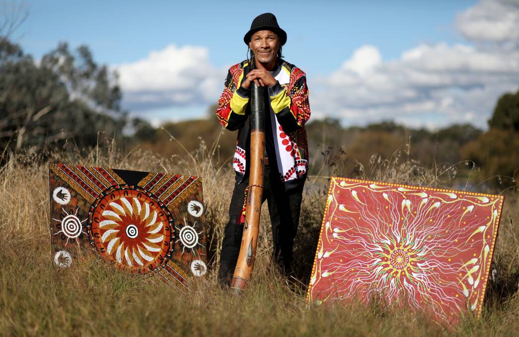 Artist Greg Joseph at the Burrunju Aboriginal Art Gallery at Yarramundi Reach in Canberra, with one of his works (right), and a piece by Linda Huddleston on the left. Picture: James Croucher