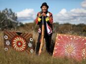 Artist Greg Joseph at the Burrunju Aboriginal Art Gallery at Yarramundi Reach in Canberra, with one of his works (right), and a piece by Linda Huddleston on the left. Picture: James Croucher