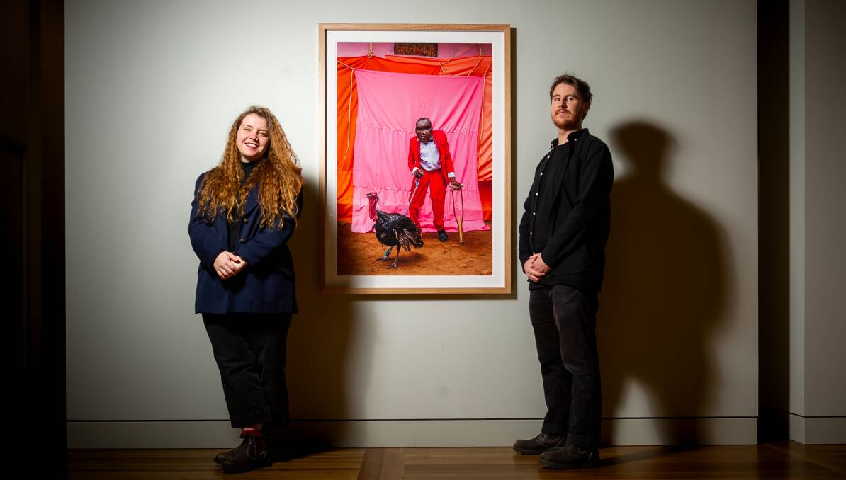 Art handlers Jessica Kemister and Jacob Potter with their favourite from the 2023 National Photographic Portrait Prize by David Cossini. Picture by Elesa Kurtz