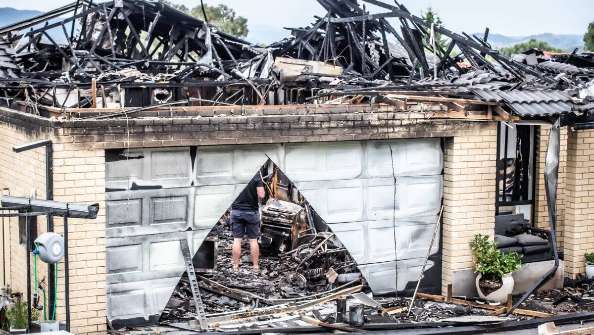 A homeowner searches for something to salvage from the housefire that decimated his home in Banks. Picture: Karleen Minney