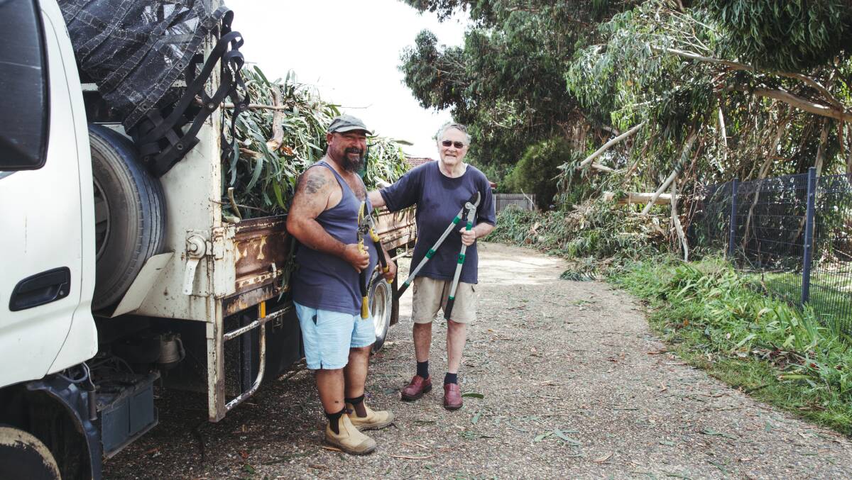 Holt residents Pepi Millucci and Bernie Brooks help clean up the aftermath of a severe thunderstorm which swept through Belconnen. Picture: Dion Georgopoulos
