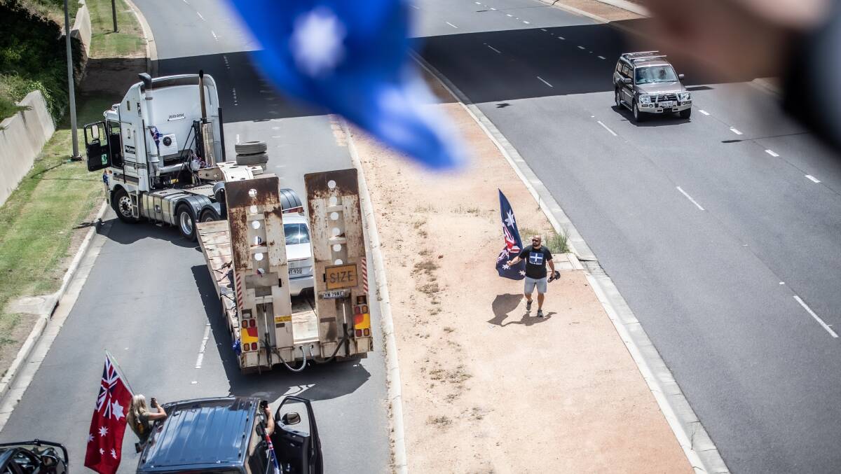 Anti-vax protesters gather in front of Parliament house while a truck driver is cautioned by police officers for intentionally jack-knifing his truck on the State Circle. Picture: Karleen Minney