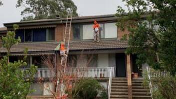 Workers on the roof with the tied ladders. Picture supplied