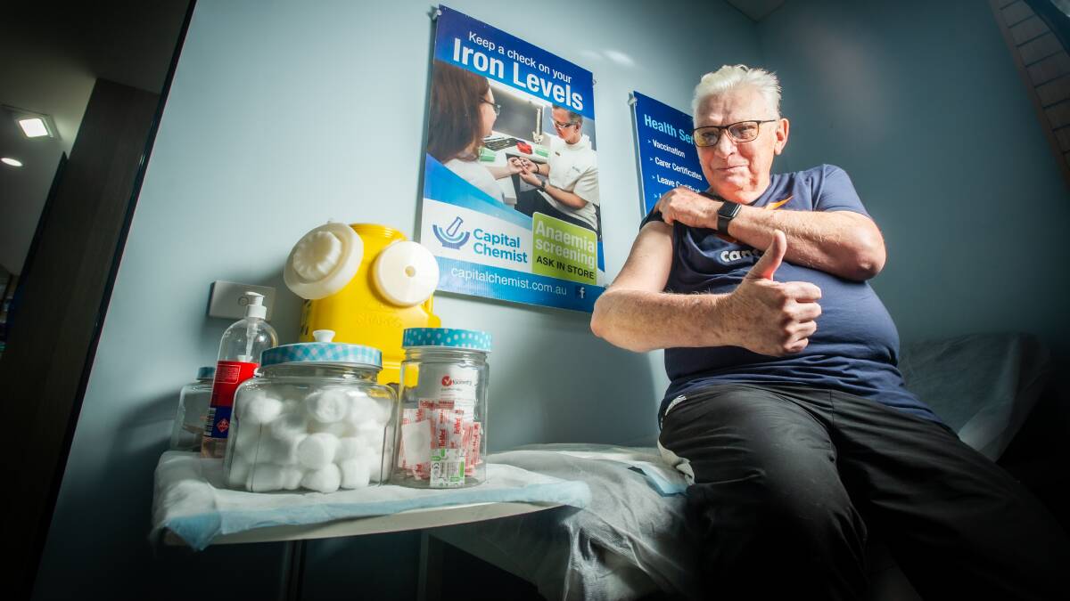 Fourth vaccination dose for eligible people began Monday. John Fielding of Downer receives his second booster from pharmacist Grace Lee at the O'Connor Capital Chemist. Picture: Karleen Minney