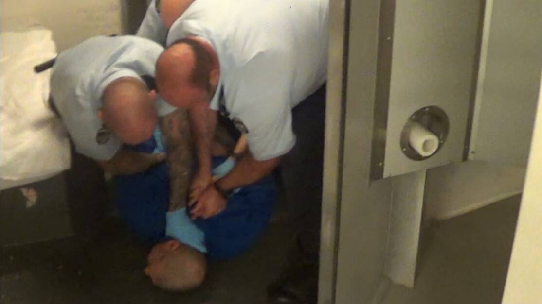 Corrections officers forcibly extracting Paul Palmer from his cell. Picture supplied