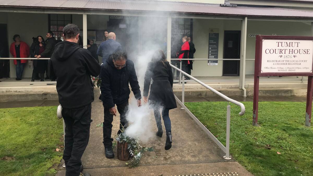 Family and friends of Tumut woman Naomi Williams hold a smoking ceremony outside Tumut Court House on Monday, before a coroner delivered her final findings on Ms Williams' death. Picture: Finbar O'Mallon