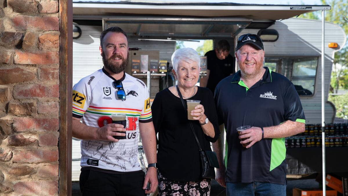 Pictured alongside Junee's Mitchell Sweeney and Jason Crowder grabbing a Friday afternoon drink, Tumut's Kate Pearce shows her support for Tumut River Brewing Company at a fundraising event hosted by Junee Licorice and Chocolate Factory. Picture by Madeline Begley for The DA. Friday 22 September 2023, Junee.