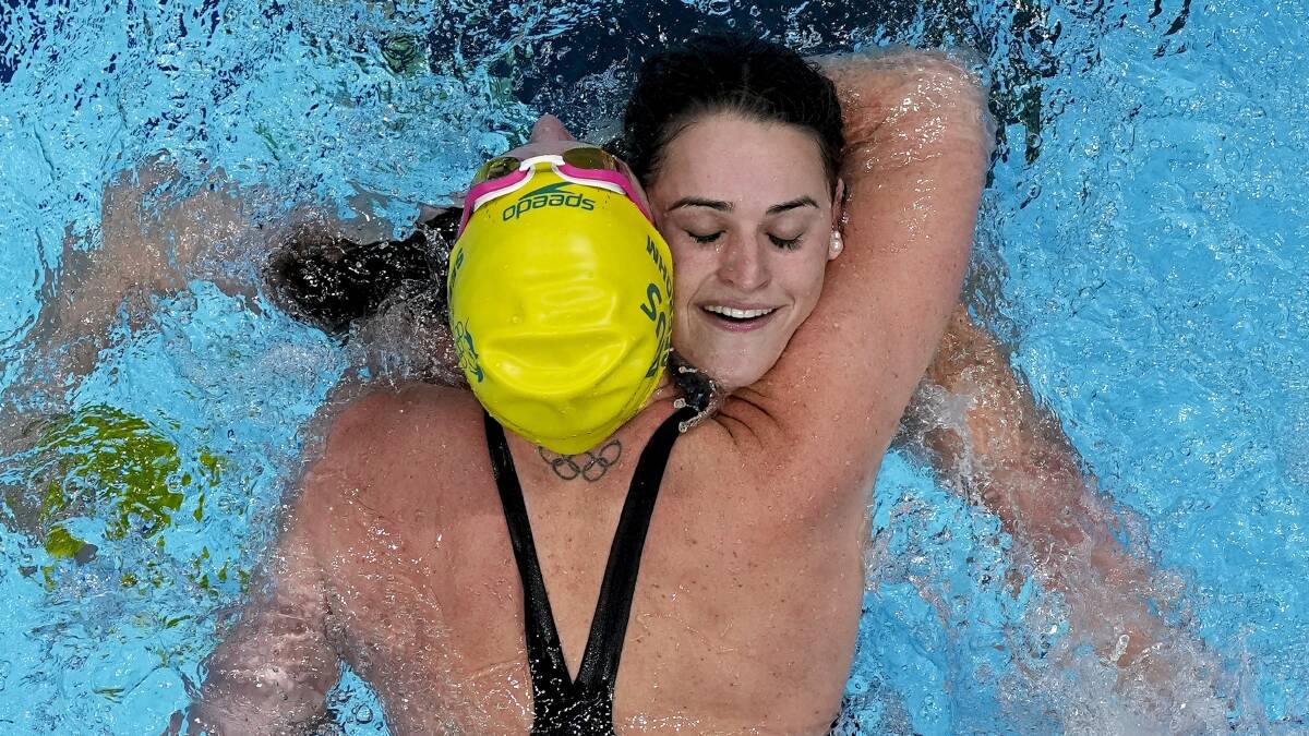 Kaylee McKeown, of Australia, is congratulated by teammate Emily Seebohm after winning the final of the women's 100m backstroke. Photo: AP Photo/Morry Gash