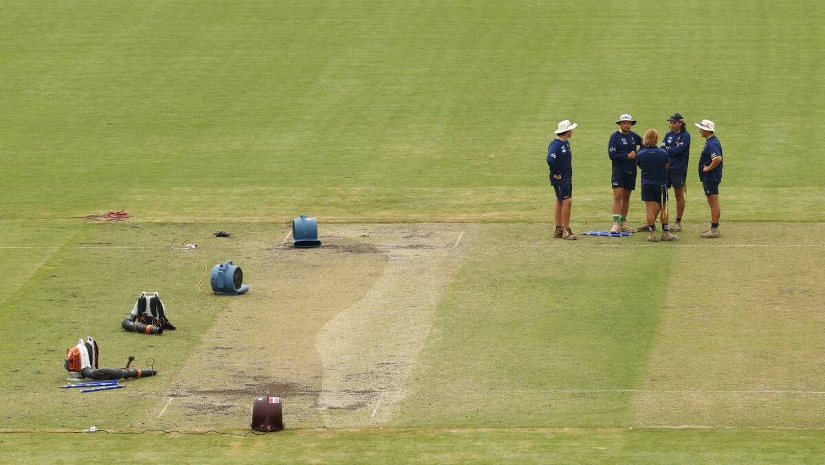 Curators inspect the damage at Manuka Oval after the ground was hit by Friday night's freak storm. Picture by Keegan Carroll
