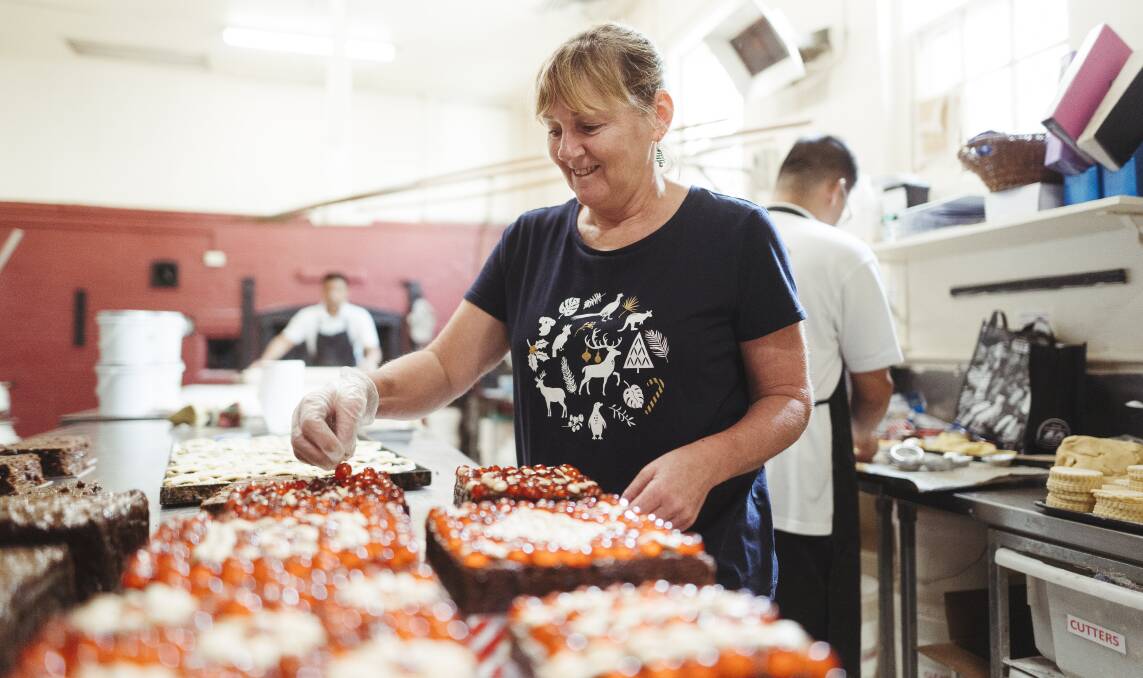 Braidwood Bakery manager Louise Moran applies the finishing touches to some glazed Christmas cakes. Picture: Dion Georgopoulos