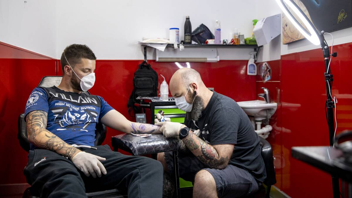 Tattoo Xtreme tattoo artist Steven McPhee inks Lochie Carnegie from Belconnen. Picture: Sitthixay Ditthavong