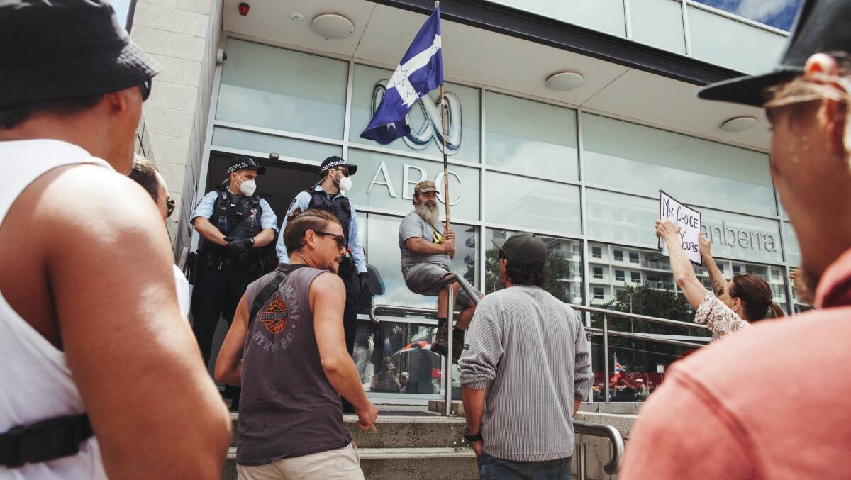 A Eureka Flag-waving protester mans the balustrade during a protest outside the ABC building on Monday. Picture: Dion Georgopoulos