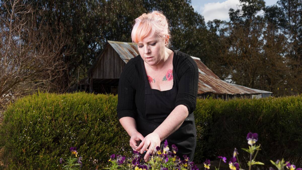 Head chef Jennie Tressler collects edible flowers from the garden. 