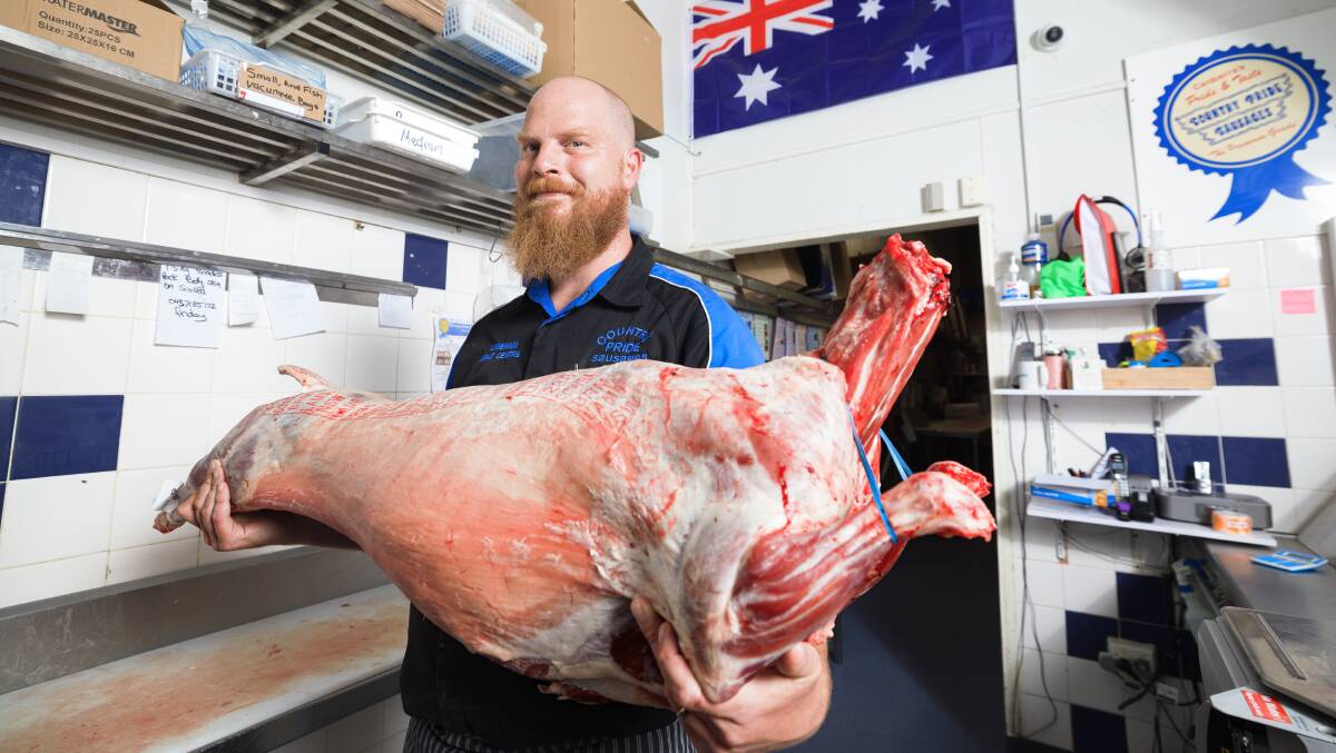 Lyneham Meat Centre shop manager Dave Chapman with a whole lamb carcass. Picture by Sitthixay Ditthavong