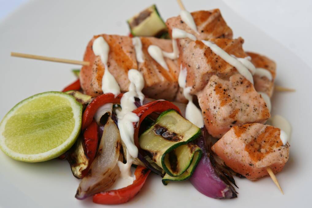 Char-grilled salmon kebabs and vegetables with lime mayo. Picture: Supplied