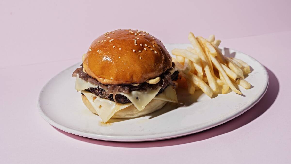Beef burger with brisket, Swiss cheese, caramelised onion, mustard and fries. Picture: Supplied