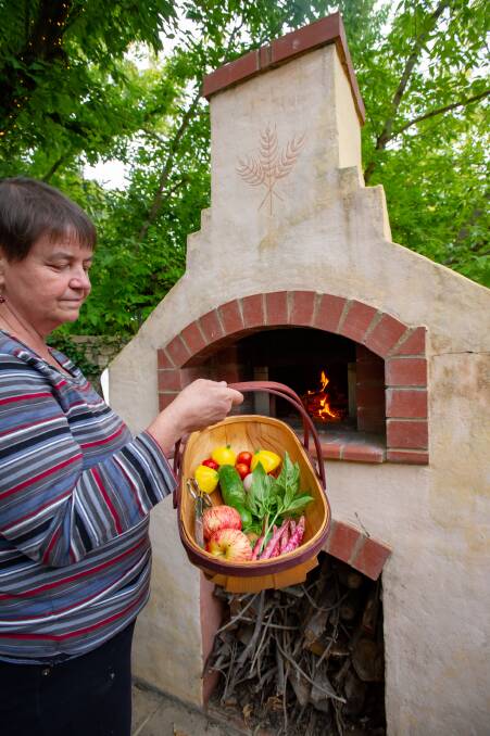  Pizza oven aglow with just harvested vegetables and fruit plus eggs. Picture: Elesa Kurtz
