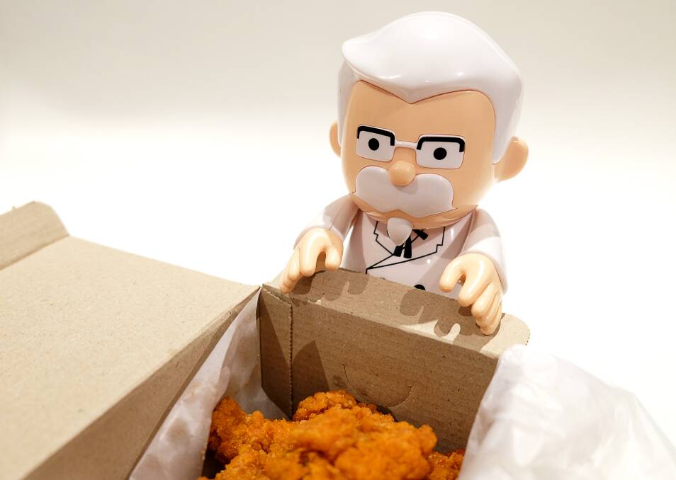 A Colonel Sanders figurine looking over its model's creation. Picture: Shutterstock