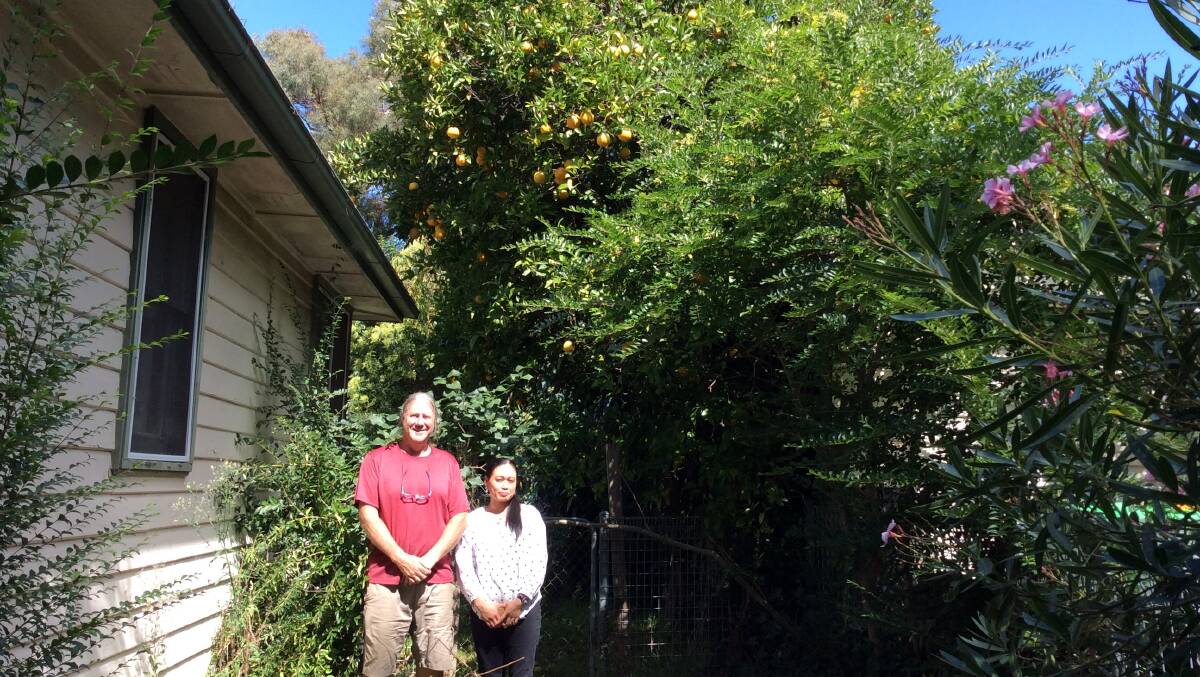 Dave Rowell and Loulu Roswati in front of the orange tree in OConnor. Picture: Susan Parsons