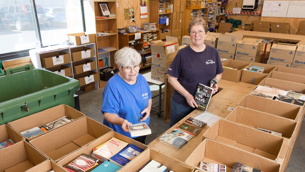 Dorothy Dockett, left, and Julie McNamara sorting books for the Lifeline Bookfair. Picture by Sitthixay Ditthavong