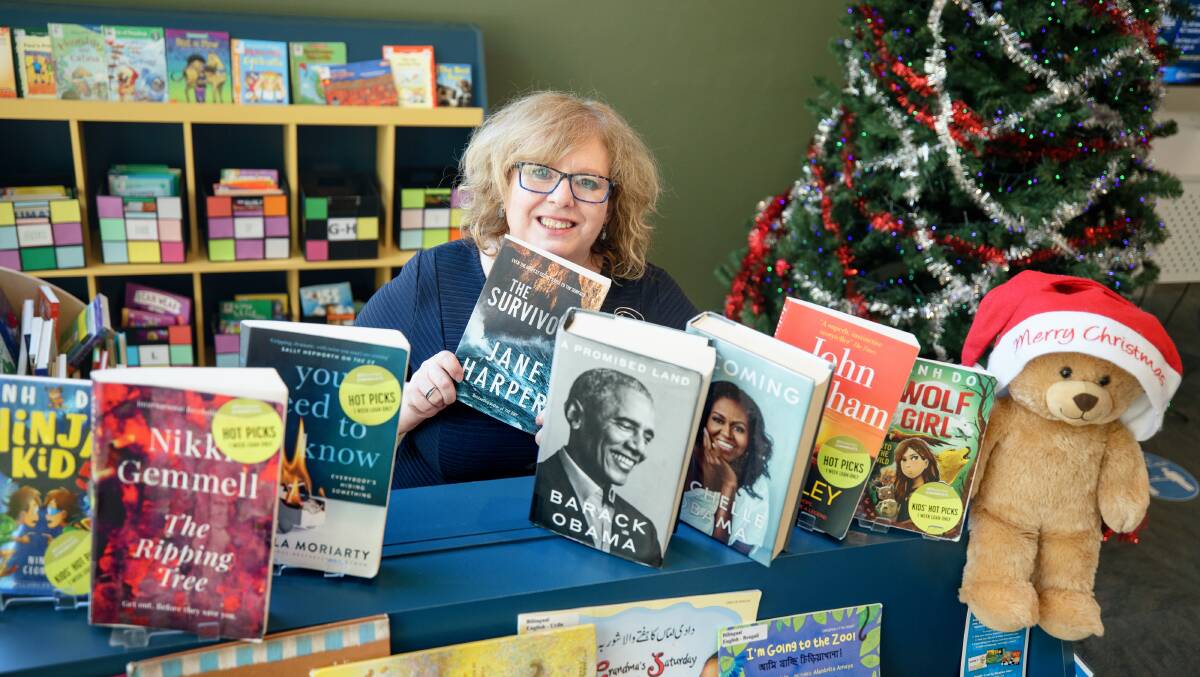 Libraries ACT executive branch manager Vanessa Little with some of 2021's most borrowed books. Picture: Sitthixay Ditthavong