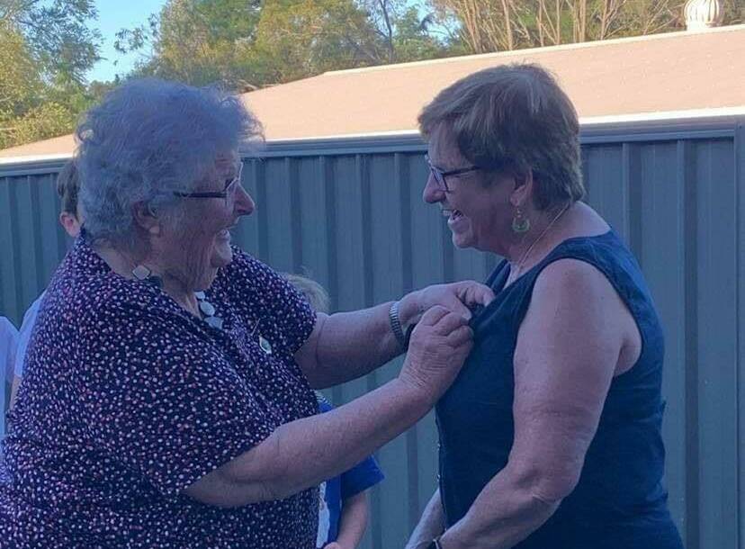 Ena Williams presents a shocked Pauline Gray with her life membership badge.