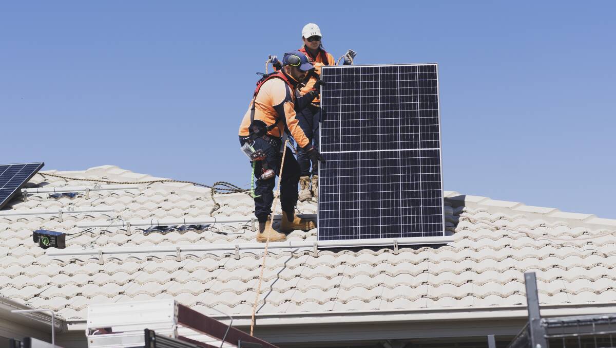 Canberra SolarHub employees install solar panels on a house in Bonner. Picture: Dion Georgopoulos